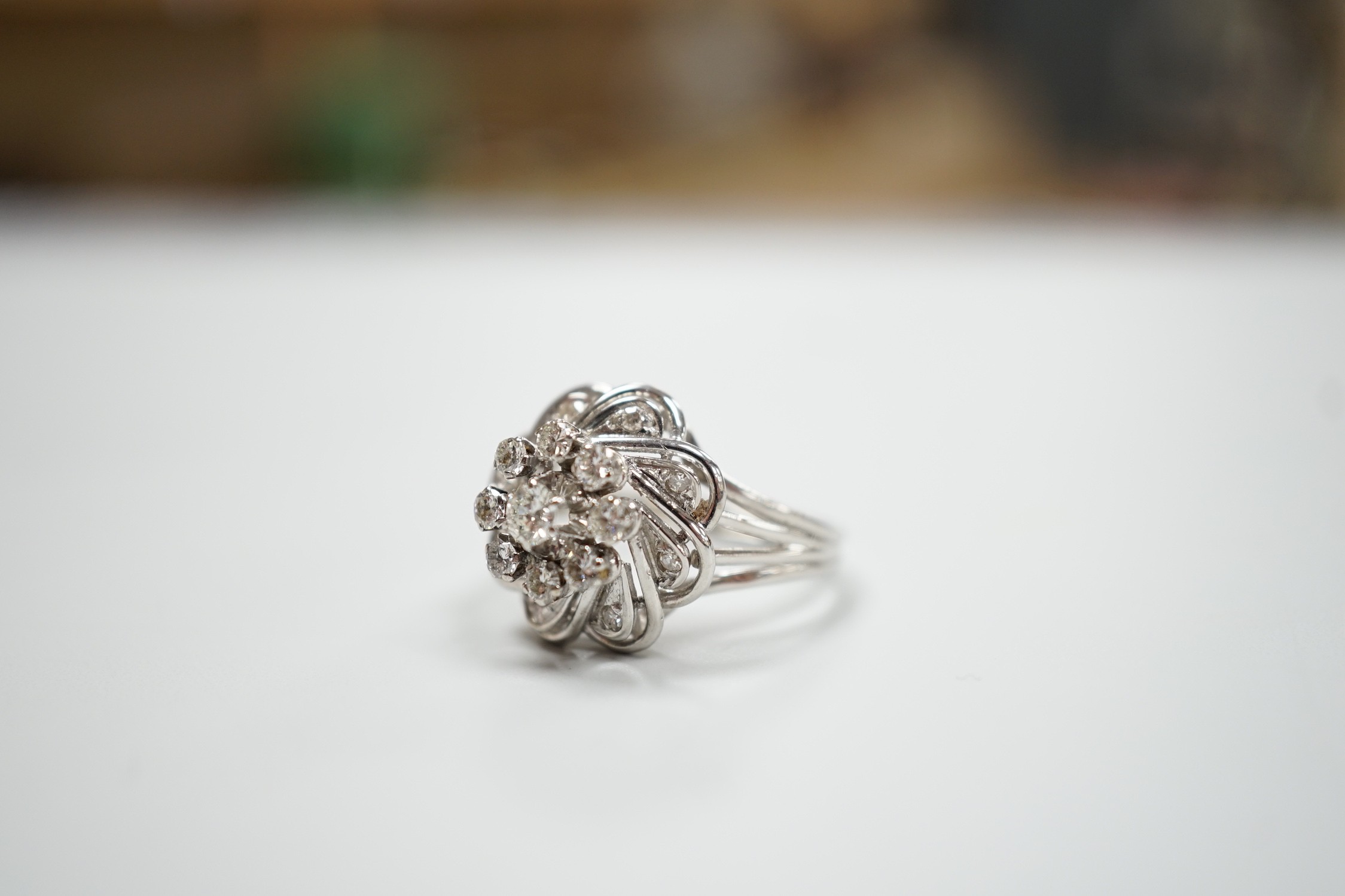 A French white metal (18ct poincon mark) and diamond cluster set dress ring, size L/M, gross weight4.8 grams.